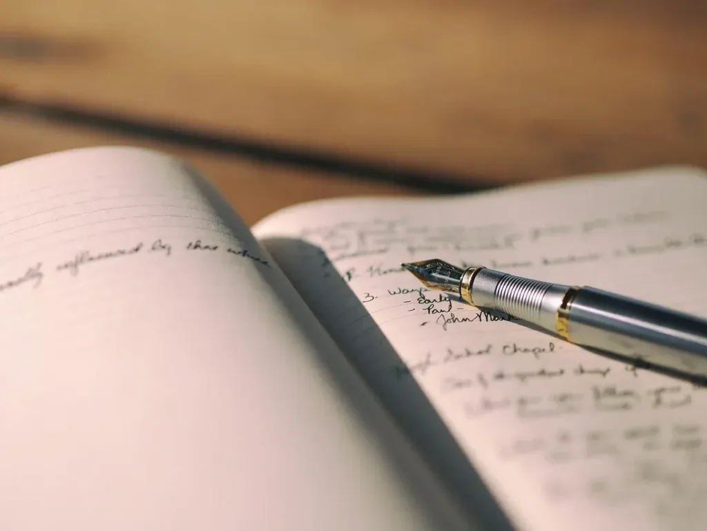 Otwarty notes z odręcznymi notatkami i piórem, dziennik myśli
